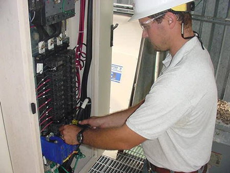 Electrician installing a type 2 surge protector at a main breaker panel in new haven
